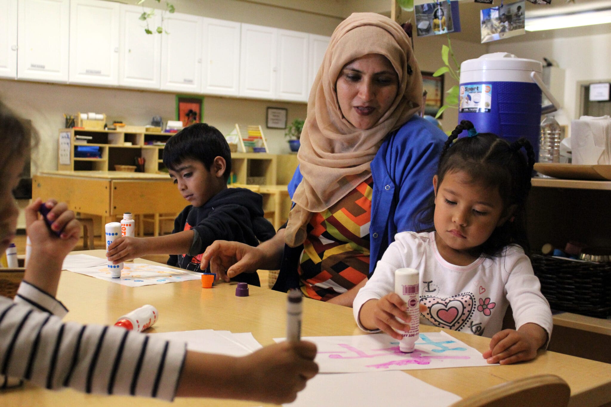 Early educator is helping a student with their activity.