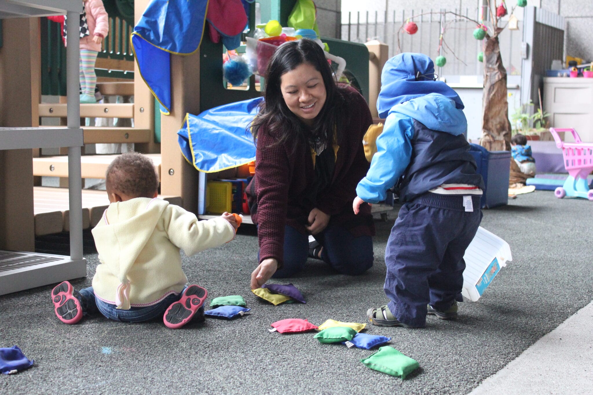 A child caretaker playing with two children.