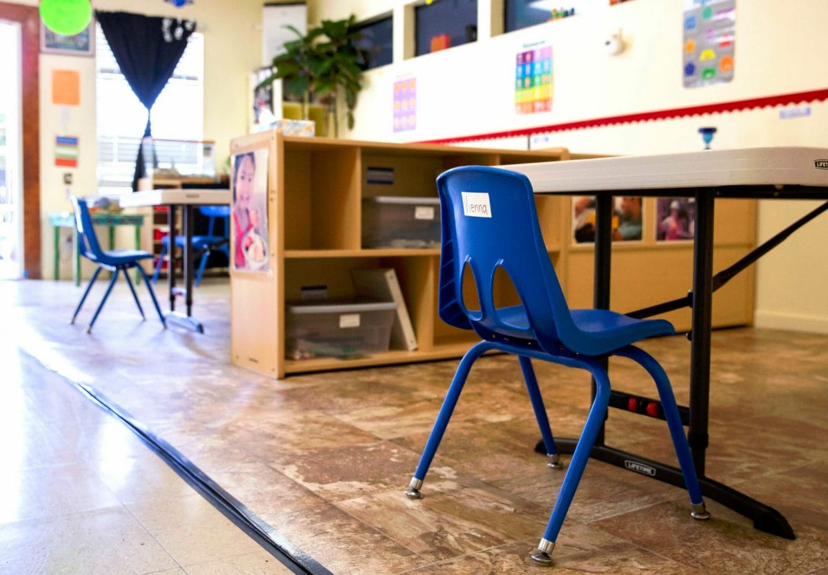 An empty early childhood classroom with an open door, no teacher in sight