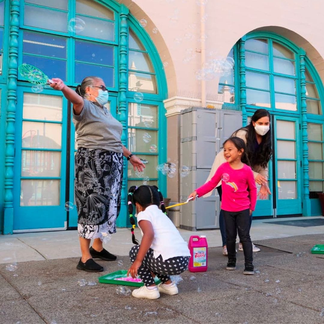 An early educator is helping children with their activity.