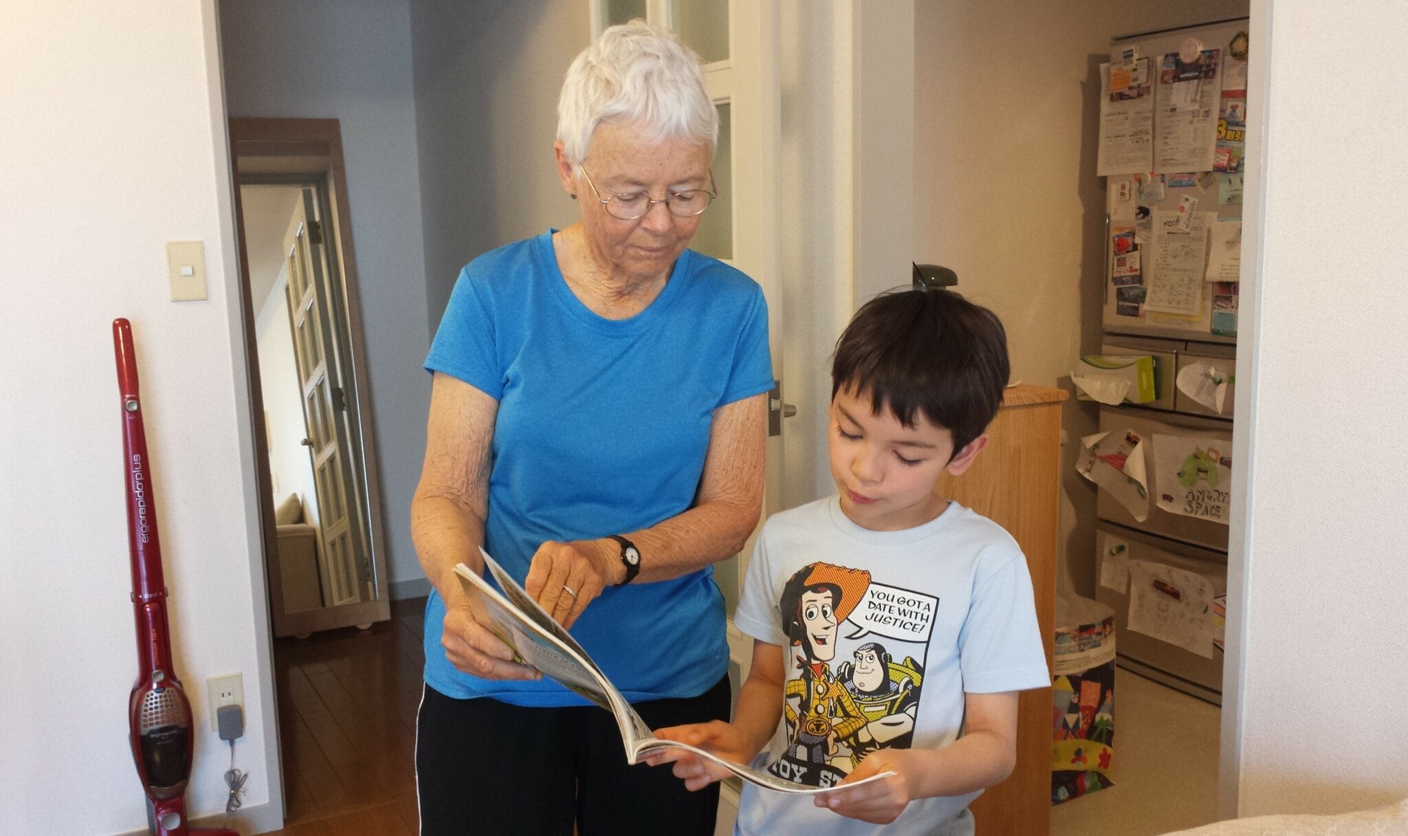 An elderly woman reads a book with a young child.