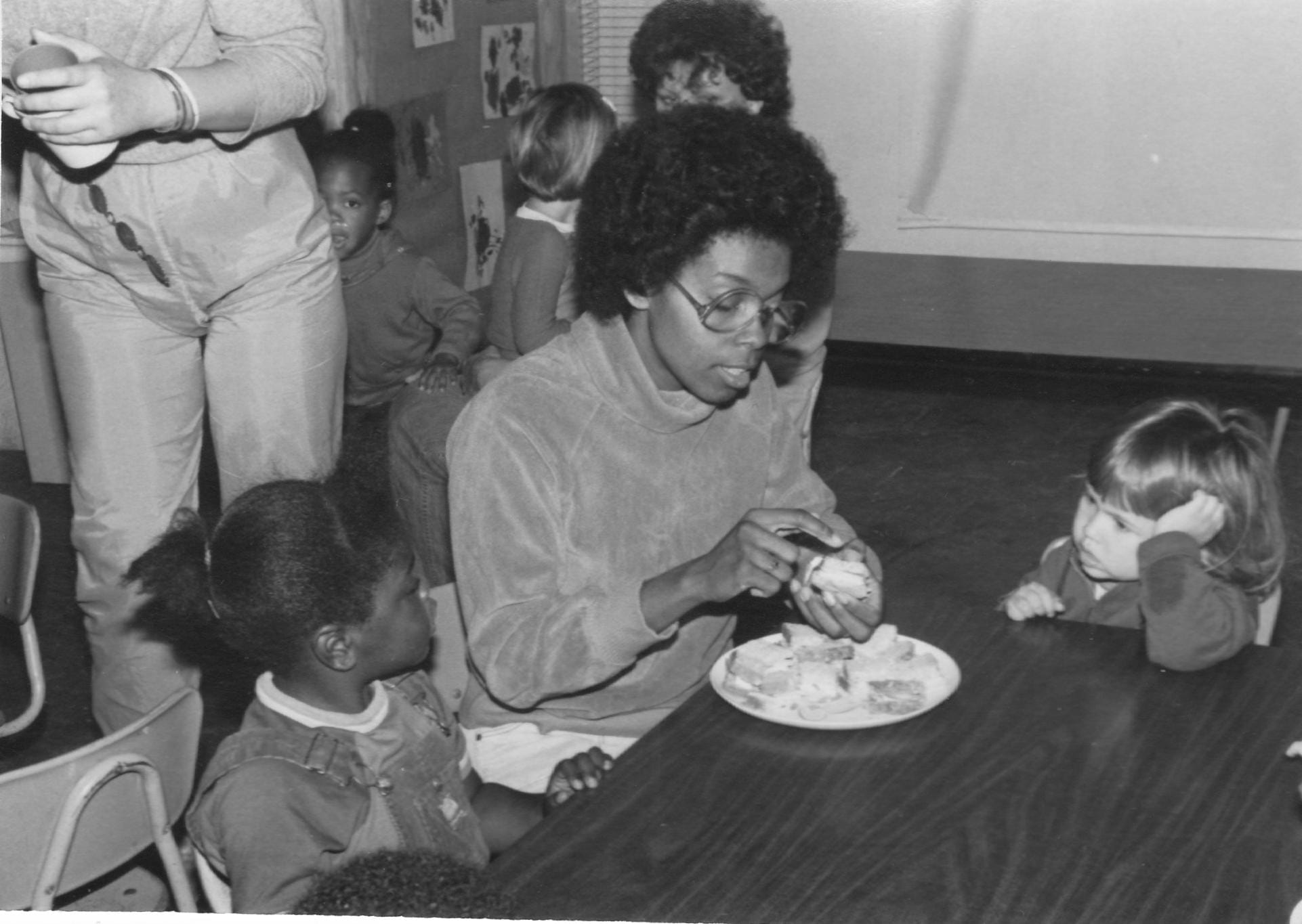 B11teacher Bl With Children At Snack Table