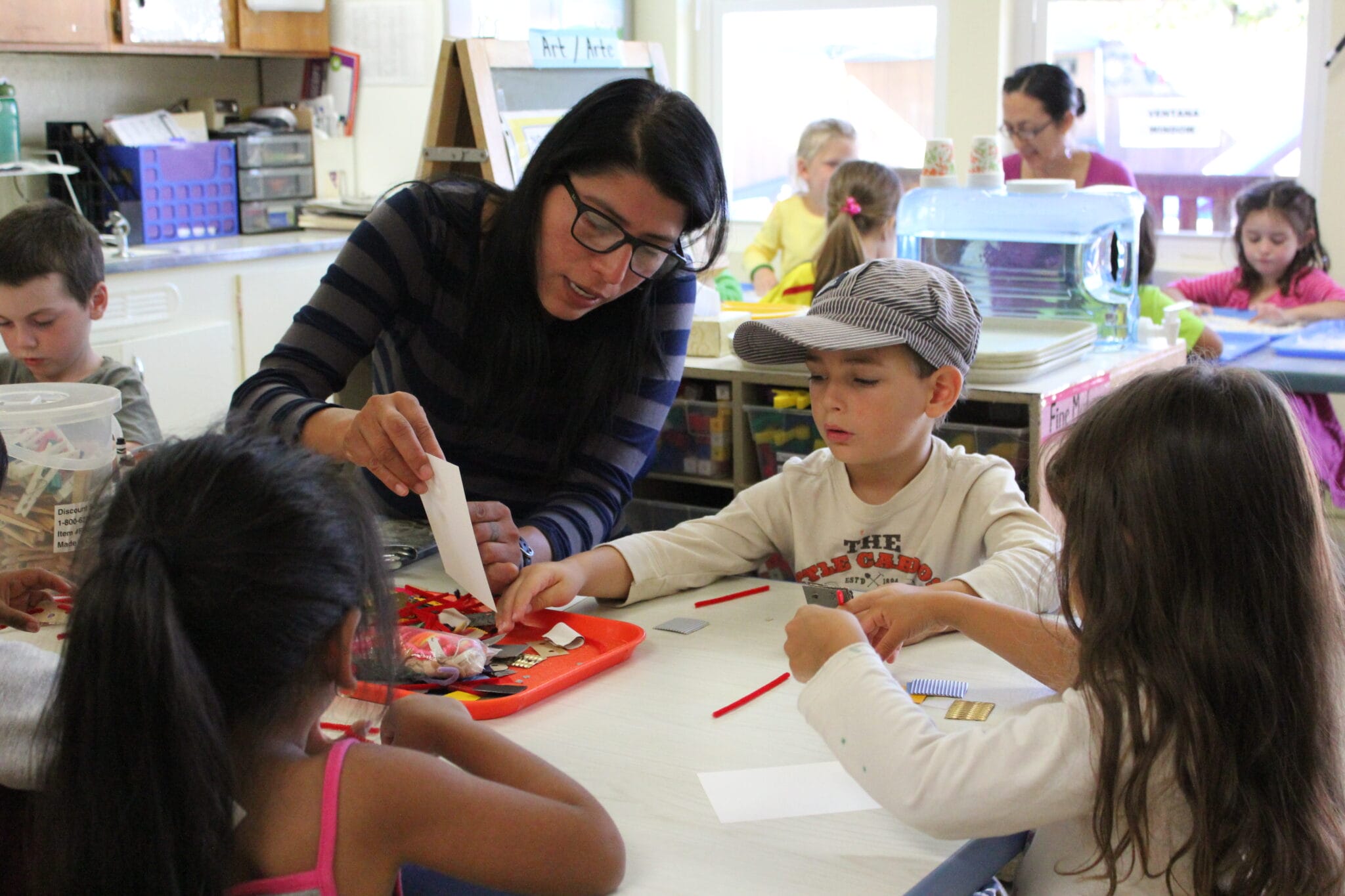 Child care worker demonstrating an activity to a group of kids.