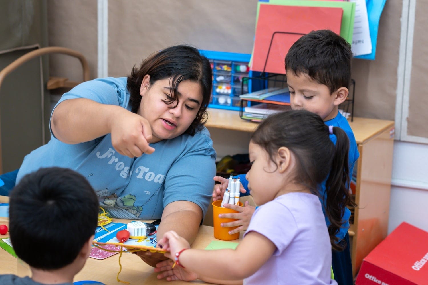 A teacher and students do arts and crafts.
